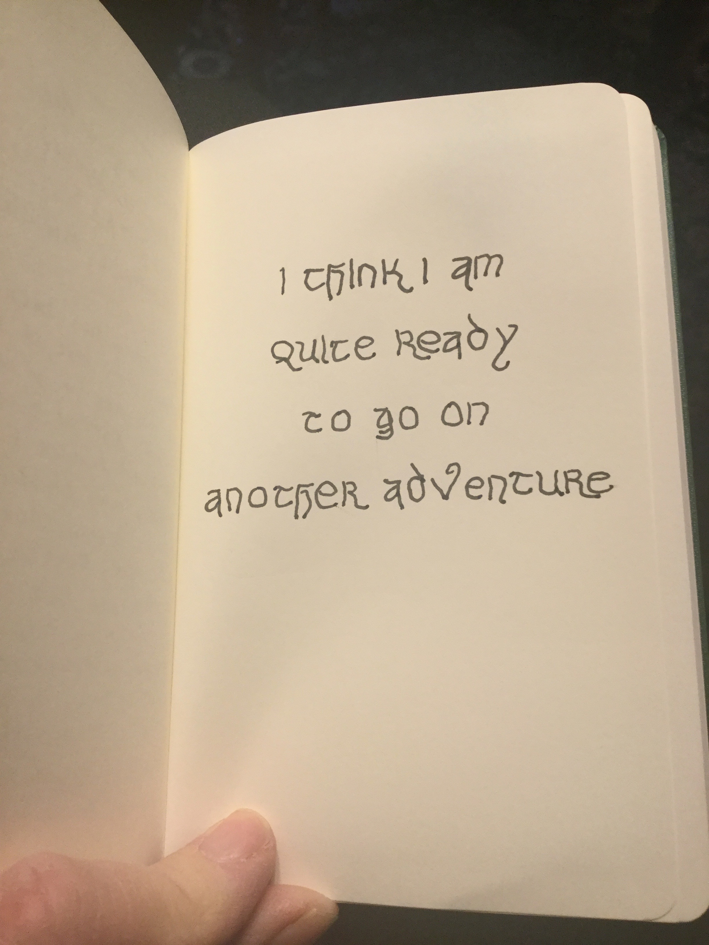 Moleskine notebook open to a page on which is written: "I think I am quite ready to go on another adventure."