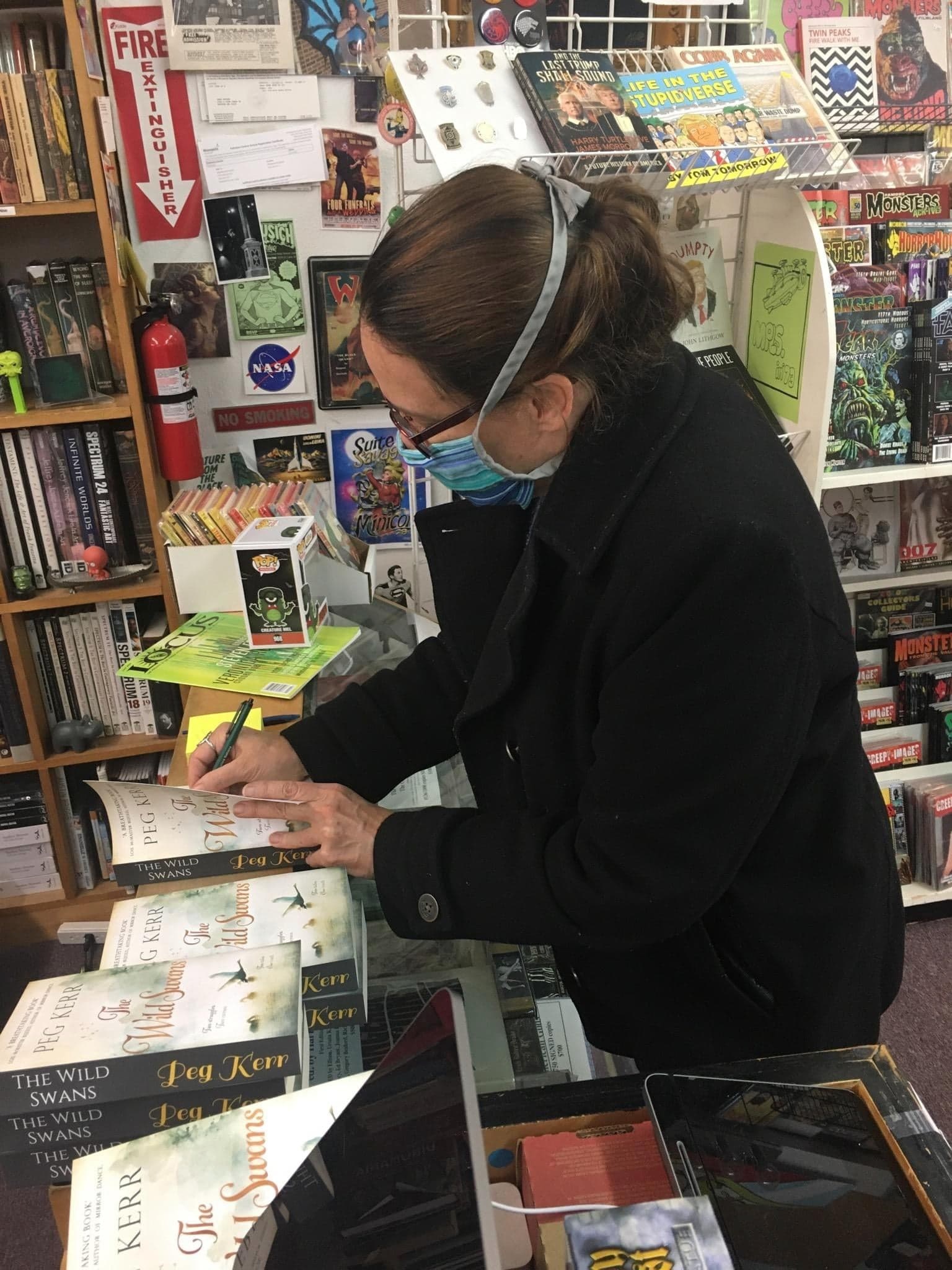 Peg signs copies of The Wild Swans at Dreamhaven Books and Comics