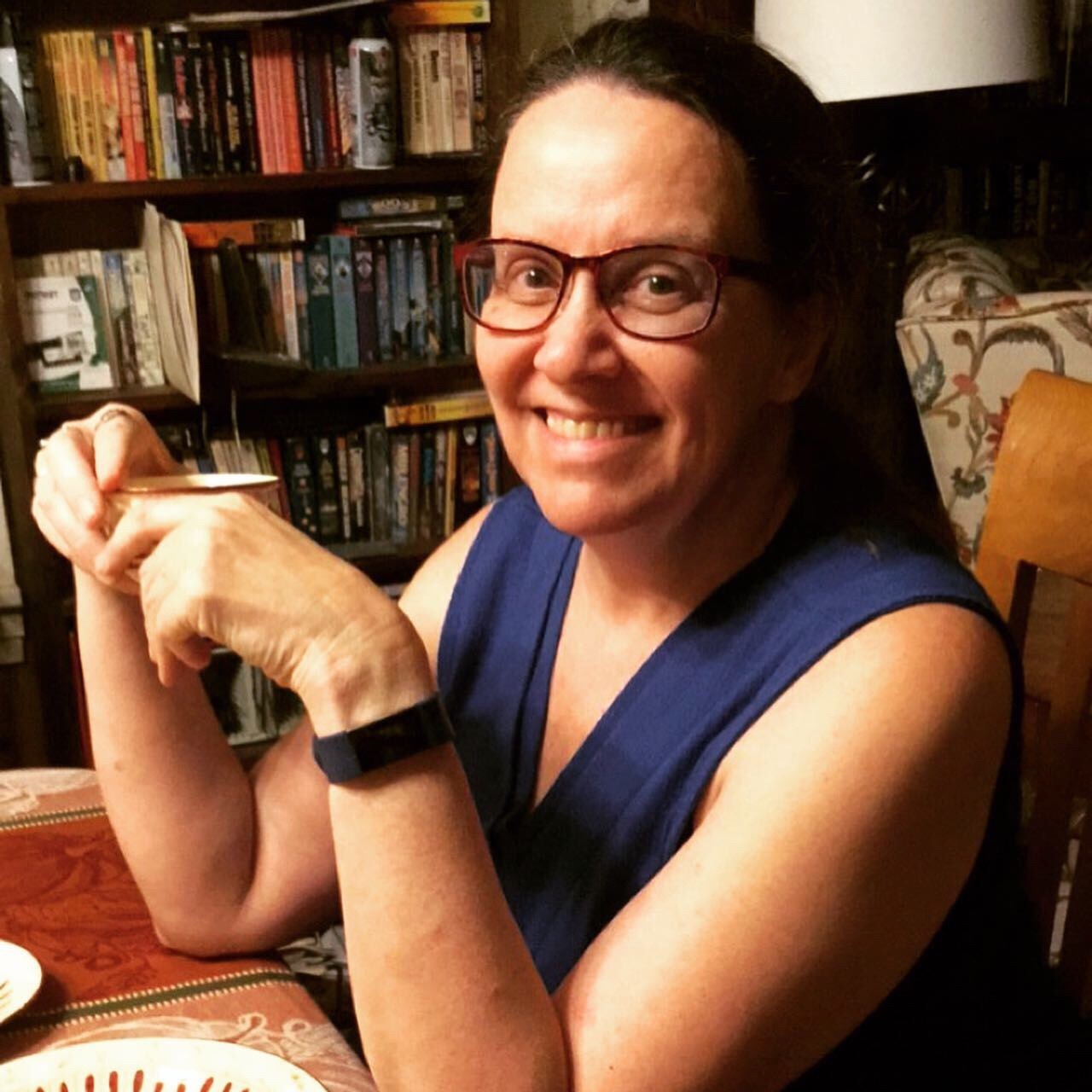 Peg Peg holds a teacup, seated at a table